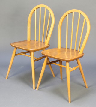 A pair of Ercol light elm stick and hoop back kitchen chairs with H framed stretchers, raised on turned supports 