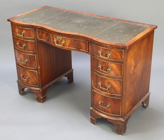 A Georgian style desk of serpentine outline, having a crossbanded top inset a green leather writing surface above 1 long and 8 short drawers, raised on bracket feet 30"h x 45 1/2"w x 21"d 