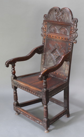 An 18th Century carved and inlaid oak Wainscot chair with geometric carved decoration and scroll arms 