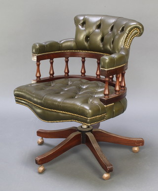 A mahogany revolving tub back office chair upholstered in green buttoned leather 