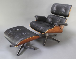 A Charles Eames lounge chair and foot stool, upholstered in black leather and with rosewood veneered frames