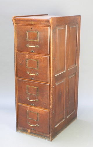 An Edwardian oak 4 drawer filing cabinet with panel decoration to the sides and brass handles 53"h x 18"w x 29"d 