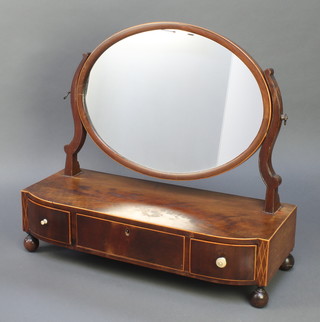A 19th Century oval plate dressing table mirror contained in a mahogany swing frame, the bow front base fitted 1 long and 2 short drawers, raised on turned supports 21"h x 23"w x 9"d 