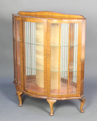 An Art Deco walnut bow front display cabinet, fitted shelves enclosed bv glazed panelled doors, raised on 4 cabriole supports 47"h x 40"w x 14 1/2"d 