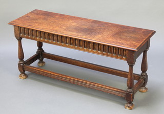 A rectangular oak stool with arcaded decoration, raised on turned and block supports 18"h x 39"w x 13 1/2"d