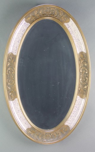 An oval bevelled plate wall mirror contained in a gilt and painted frame 21" x 13 1/2" 