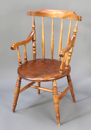A Victorian elm stick and rail back Windsor chair with solid elm seat raised on turned supports with H framed stretcher