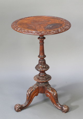 A Victorian circular carved and figured walnut wine table raised on a carved baluster column and tripod base 30"h x 20" diam. 