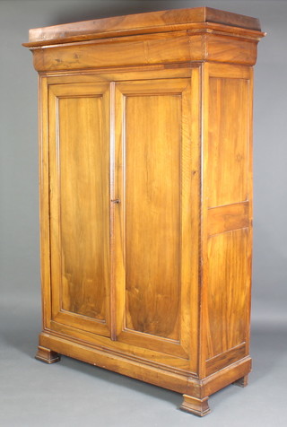 A Continental walnut cupboard with moulded cornice the shelved interior enclosed by panelled doors, raised on square supports 