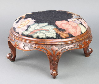 A Victorian circular carved mahogany show frame footstool the seat upholstered in Berlin woolwork 5" x 10 1/2" diam. 