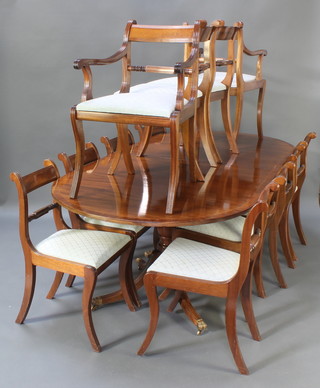 A Georgian style mahogany dining suite comprising D end oval extending twin pillar dining table with 2 extra leaves, having a crossbanded top, raised on a turned column and tripod support 29"h x 42"w x 87 1/2" x 125" when extended, together with a set of 12 bar back dining chairs with shaped mid rails - 2 carvers and 10 standard 