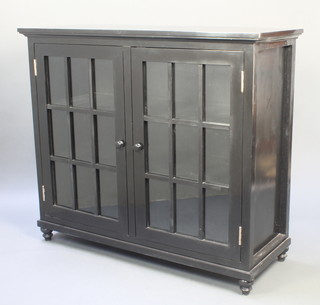 After Rennie Mackintosh, an ebonised dining room suite comprising rectangular cabinet enclosed by astragal glazed panelled doors raised on turned supports 42"h x 48"w x 18 1/2"d together with 6 bar back dining chairs - 2 carvers, 4 standard