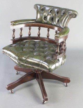 A mahogany and leather revolving office chair upholstered in buttoned green leather 