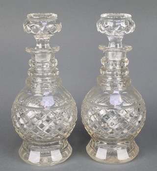 A pair of cut glass mallet shaped decanters and stoppers with 3 ring necks 12"