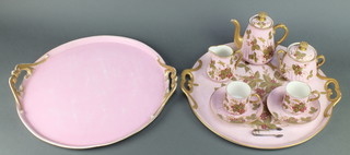An early 20th Century French porcelain cabaret set decorated with flowers and insects on a pink ground comprising 2 handled tray 16", a coffee pot, milk jug, lidded sugar bowl, 2 coffee cans and saucers together with a similar tray 