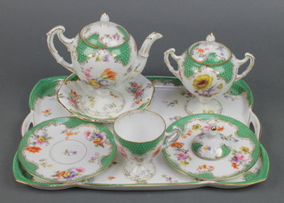 A Continental breakfast porcelain set comprising teapot, lidded sugar bowl, tea cup and saucer, saucer dish  and tray decorated with spring flowers
