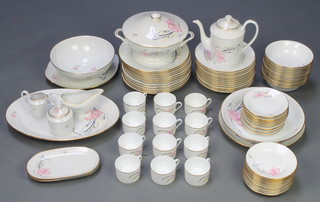 A modern Limoges coffee and dinner service comprising 12 coffee cups, 12 saucers, 12 small plates, 12 dinner plates, 12 soup bowls, 12 dessert bowls, a tureen and lid, fruit bowl, 3 serving plates, a shallow bowl, sauce boat, sugar pot and lid and cream jug with stylised floral decoration and gilt enamelled D 