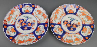 A pair of early 20th Century Imari plates with panels of flowers and trees 12" 