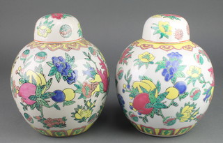 A pair of 20th Century Chinese famille rose ginger jars and covers decorated with peaches 9" 