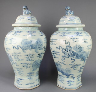 A pair of 18th Century style octagonal blue and white oviform vases decorated with dragons having lion finials 23" 