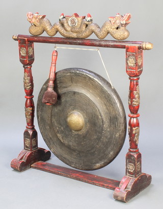 A large circular Tibetan tribal drum hung as a gong raised on a pierced and carved hardwood stand complete with beater 42"h x 39"w x 13"d 