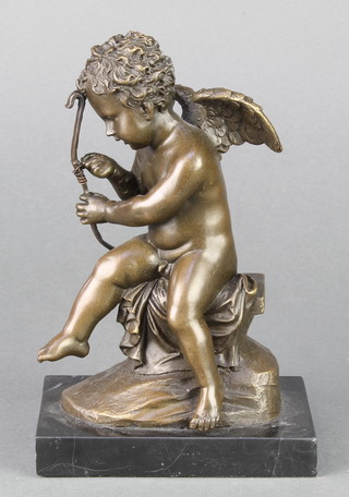 A bronze seated figure of Cupid raised on a rectangular marble base 8" 
