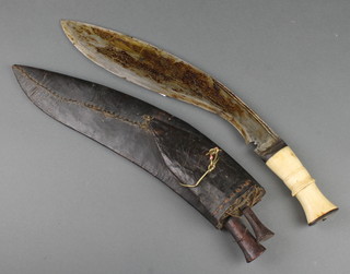 A Kukri with 13 1/2" blade, leather scabbard and horn grip complete with skinning knife