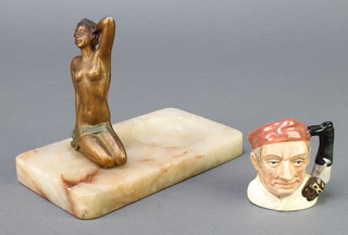 An Art Deco spelter and white marble ashtray decorated a figure of a kneeling lady 7" and a Royal Doulton miniature character jug - Characters of Williamsburg 