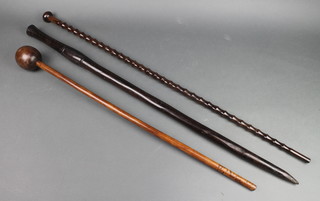 A carved wooden knobkerrie, an African carved cane and a lignum vitae cane  