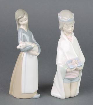 Two Lladro figures, a boy kneeling holding a present  6 1/2" and a girl with piglet 6 1/2" 