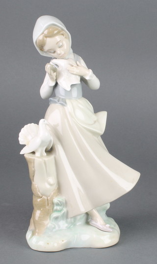 A Lladro figure of a girl holding a dove 9" 