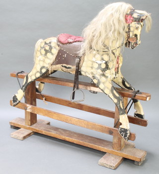 A dappled grey rocking horse with real hair mane and tail on a wooden frame base 50"h x 53"l x 18"d
