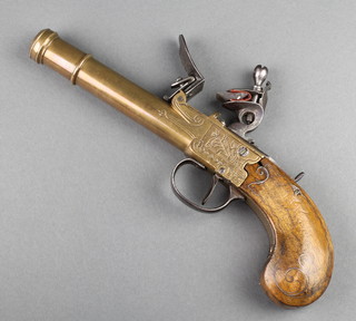 A 19th Century Continental brass barrelled flintlock pistol with 6" barrel etched military trophies and with an inlaid walnut grip 