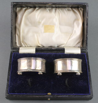 A pair of circular silver table salts with blue glass liners Birmingham 1944, 36 grams, cased