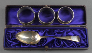 An Edwardian silver dessert spoon London 1907,cased, and 3 napkin rings 110 grams
