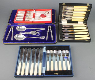 An Edwardian cased silver plated set of nut crackers, serving spoons and grape scissors and other cased sets