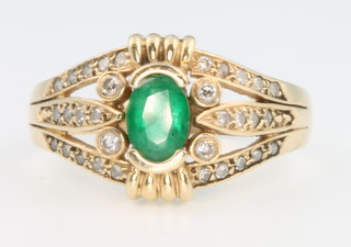 A 14ct yellow gold emerald and diamond open shank ring, the centre stone approx 1.0ct size U 1/2