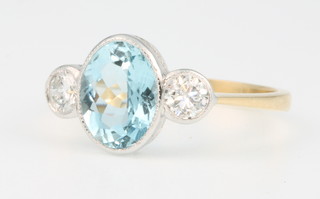 An 18ct yellow gold aquamarine and diamond ring, the oval cut aquamarine approx. 1.6ct flanked by 2 brilliant cut diamonds 0.4ct, size O 