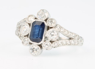 An 18ct white gold sapphire and diamond Victorian style ring, the centre baguette cut emerald approx. 0.8ct surrounded by brilliant cut diamonds approx. 0.75ct size M 1/2