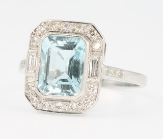 An 18ct white gold aquamarine and diamond Art Deco style ring, the centre baguette cut stone approx. 2.2ct surrounded by brilliant cut diamonds approx. 0.4ct size P 