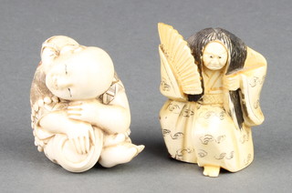 A Japanese carved ivory Netsuke of a boy holding a pan, signed 1 1/2" together with a ditto of an actor holding a fan 2"  