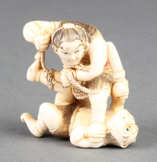 A Japanese ivory Netsuke in the form of a man fighting a demon, size 1 3/4" 