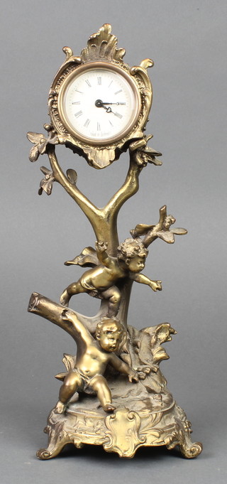 A German timepiece with paper dial contained in a gilt metal case supported by 2 cherubs 