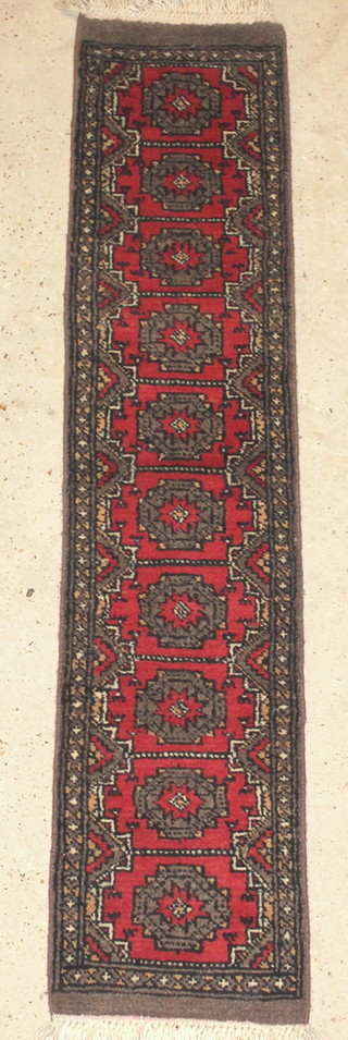 A Uzbek pink and grey ground runner with 10 stylised diamonds to the centre 59" x 13" 
