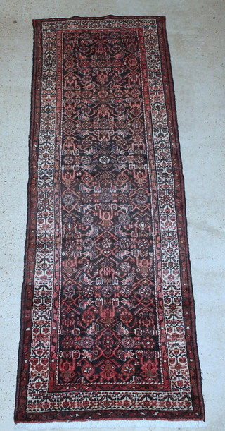 A Persian Toyserkan red and white ground runner with overall geometric design 120" x 40" 
