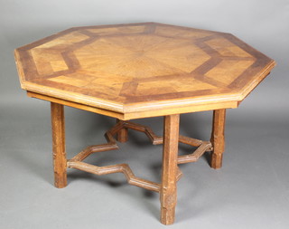 A Pugin style octagonal inlaid oak centre table with parquetry inlay to the top, raised on 4 chamfered supports with Gothic style shaped stretcher 