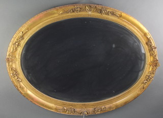 An oval bevelled plate wall mirror contained in a decorative gilt frame 36" x 26" 