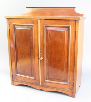 An Edwardian mahogany table top cabinet with raised back, fitted a shelf enclosed by a panelled door, raised on bracket feet 24"h x 21"w x 8" 