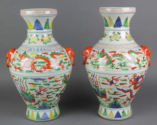 A pair of 18th Century style Chinese famille verte oviform vases with lion ring handles decorated with dragons chasing the flaming pearl 15 1/2" 