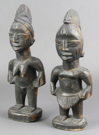 A pair of carved African Yoruba hardwood figures of a lady and gentleman 11" 